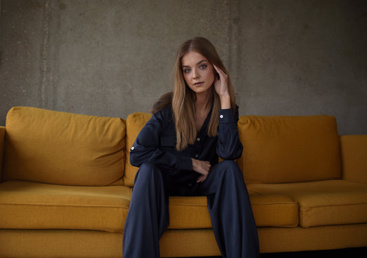 modelka w granatowym komplecie z tencelu na pomarańczowej kanapie